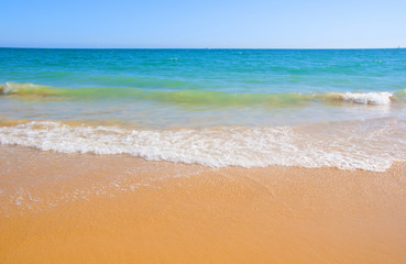 Fototapeta na wymiar Ocean shore with yelow sand and blue water, summer, Portugal 