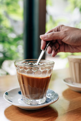Hot served Vietnamese coffee that can wake you up: Black coffee mix with condense milk in clear glass served on wooden table 
