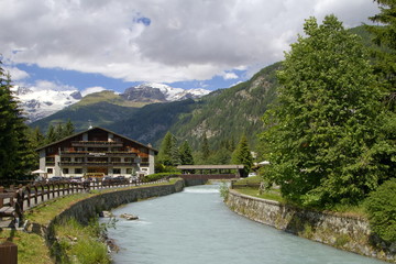 Fototapeta na wymiar champoluc con torrente e montagna in valle d'aosta italia