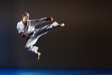 An athlete in karategi in a jump beats a kick to the side