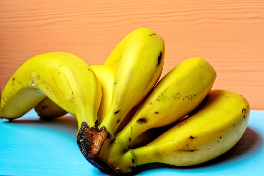 Bunch of ripe bananas on a colored background
