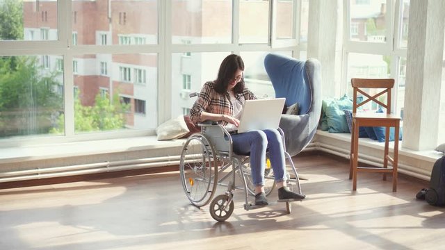 Disabled woman in wheelchair with laptop