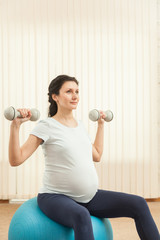 Fototapeta na wymiar Beautiful pregnant woman doing yoga