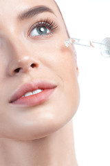 Young beautiful woman with pipette with clean perfect skin closeup