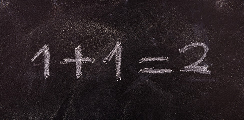 simple equation 1+1=2 isolated, on blackboard background.