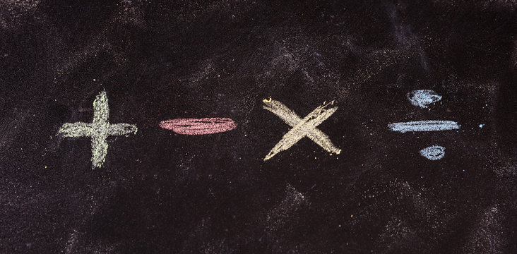 Mathematical symbols written with colorful chalks, isolated, on blackboard background.