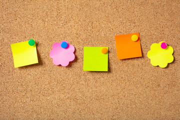 Sticky notes with pushpins, colorful in various shapes and blank space, isolated on cork background.