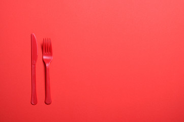 Red Fork and Knife on Bright Orange Background, Single Use Cutlery, Food Concept