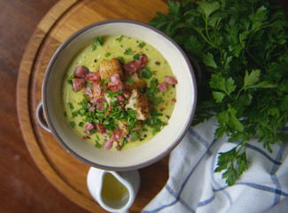 Soup with croutons and ham on the table