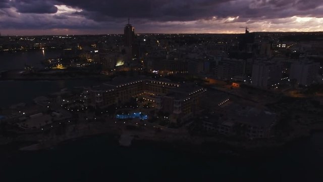 High Aerial shot orbiting around the coast of St Julians Malta