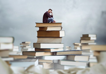 Man sits on a stack of books