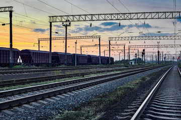 railcar for dry cargo during beautiful sunset and colorful sky, railroad infrastructure, transportation and industrial concept
