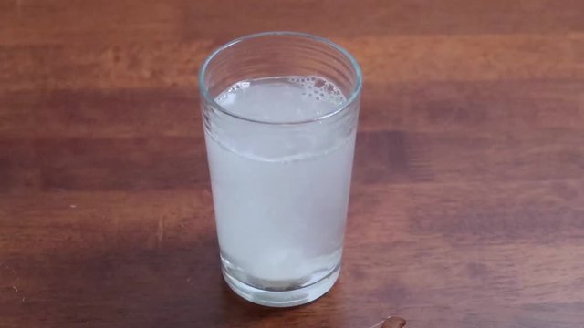 Two asprin tablets fizzing in a glass of water
