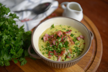 Fresh Soup with croutons and ham on a wooden table