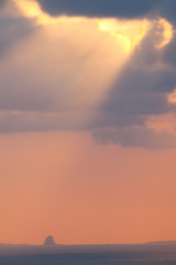 Small island with rays of sunlight