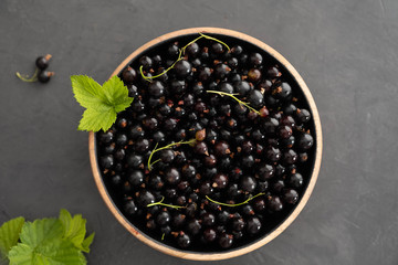 Blackcurrant berries with leaves, blackcurrant in a bowl.