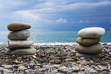 Two pyramids of stones against the blue sea. SPA