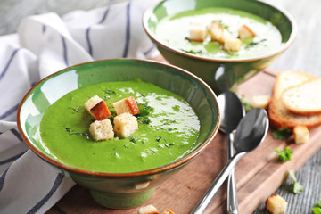 Bowl with delicious spinach soup on table