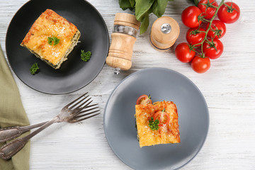 Lasagna with spinach on wooden background