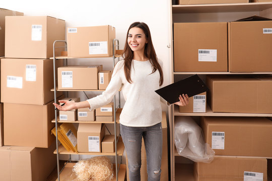 Young Woman Preparing Parcels For Shipment To Client In Home Office