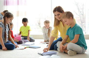 Female teacher helping boy with his homework in classroom at school