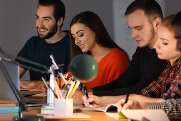 Students doing homework together indoors late at night