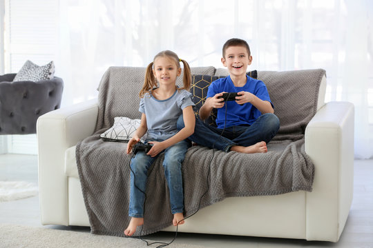 Cute children playing video games at home
