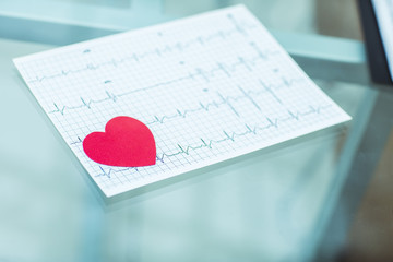 concept of health:red paper heart on the electrocardiogram, the cardiologist
