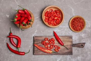 Flat lay composition with chili peppers on grey background