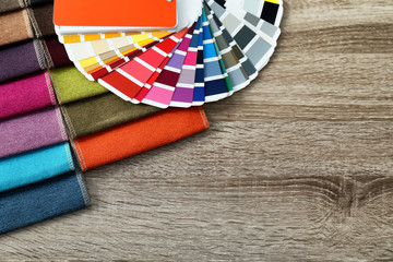 Upholstery fabric samples and color palette on table. Interior design