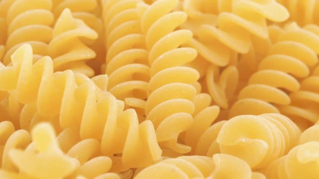 Food background, dried fusilli rotating (not loopable)