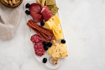 Typical italian antipasto,with prosciutto, ham, cheese and olives on white background. Top view with copy space.