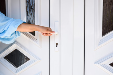 front door. hand holds doorknob on front door PVC