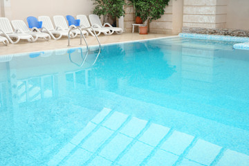 Fototapeta na wymiar Swimming pool with refreshing blue water. Time to relax