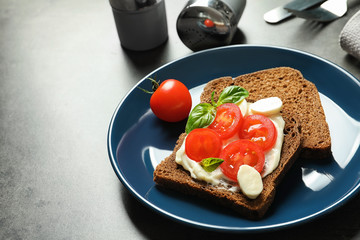 Toast bread with cherry tomatoes and mozzarella cheese on table