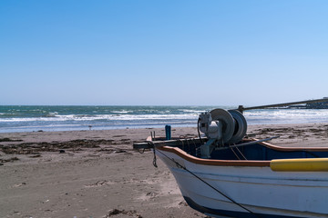 weißes Fischerboot am Sandstrand