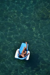 Donna prende il sole sul lettino galleggiante