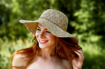 A sophisticated red-haired girl in a simple linen dress, in a light wide-brimmed hat. Model look....