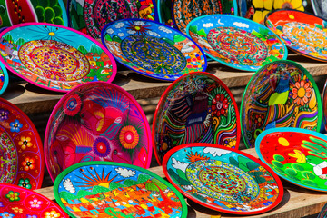 Fototapeta na wymiar Plates in the traditional Mexican style. Souvenirs from Chichen Itza, Yucatán, Mexico.