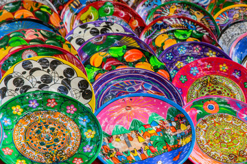 Souvenirs on the market at Chichen Itza. Maya Indians plates. Beautiful bright dishes, plates. Colorful Cookware