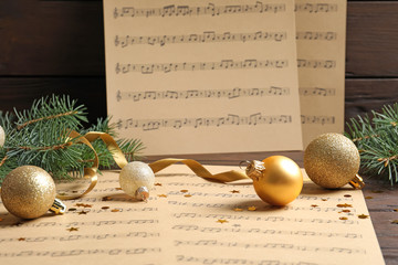 Fototapeta na wymiar Composition with Christmas decorations and music sheets on table