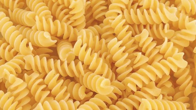 Food background, dried fusilli rotating, top view (not loopable)