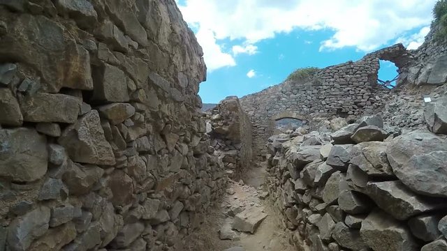 Ancient ruins of a fortified leper colony - Spinalonga (Kalydon) island, Greece climbing by stones pov