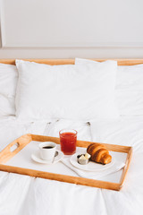 Fototapeta na wymiar Ideal breakfast in bed. Coffee, grapefruit juice and croissant with butter. Perfect early morning and start of the day.