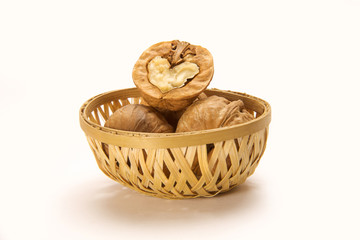 Walnuts in cane basket isolated on white background