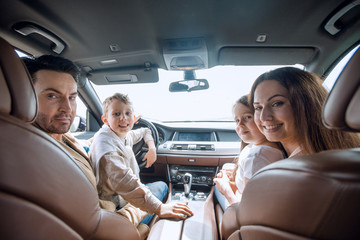 cheerful family sitting in the car