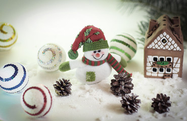 toy snowman and a gingerbread house on a light background.