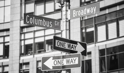 Black and white picture of Broadway and Columbus Circle street name signs, New York City, USA.