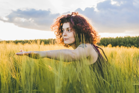 Woman Exercising While Standing At Farm Against Cloudy Sky During Sunset