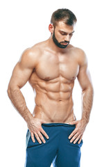 bodybuilder posing. Beautiful sporty guy male power. Fitness muscled in blue shorts. on isolated white background. Man with muscular torso. Strong Athletic Man Fitness Model Torso showing six pack abs